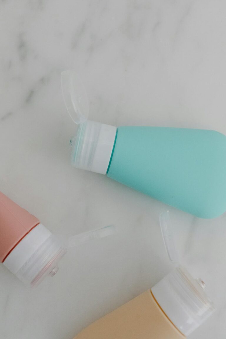 Three pastel-colored fliptop bottles on a marble background, perfect for product mockups.